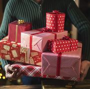 man holding stack with christmas presents