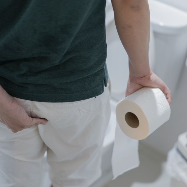 man holding toilet paper roll in bathroom