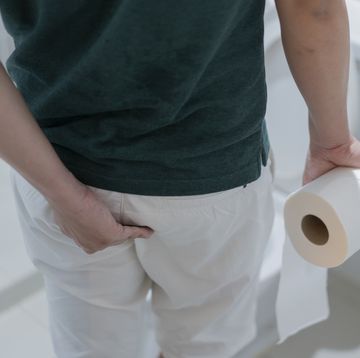 man holding toilet paper roll in bathroom