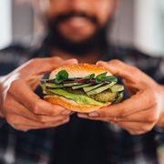 man holding vegan chickpea burger in hand