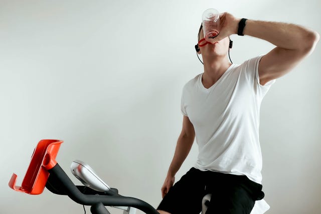 man hydrates during indoor cycling session