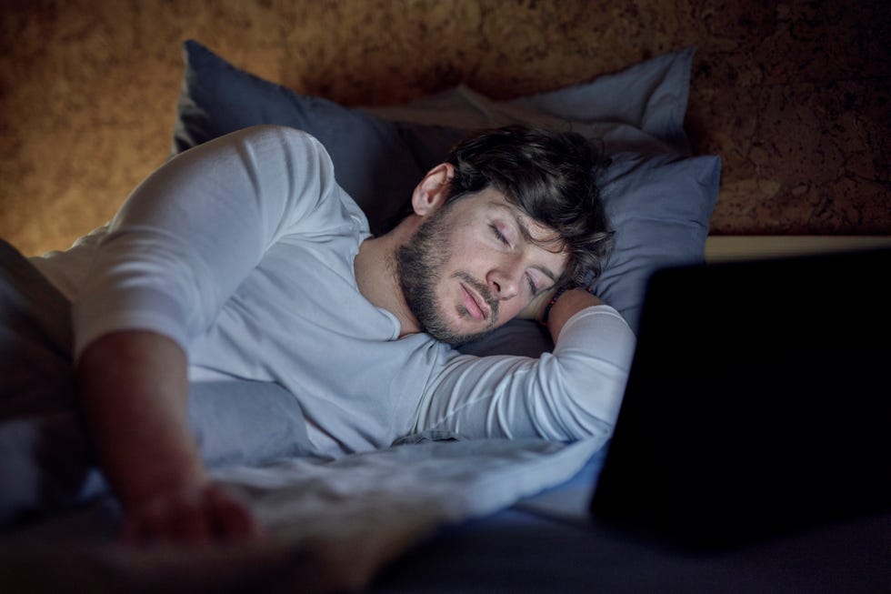 man in bed with computer