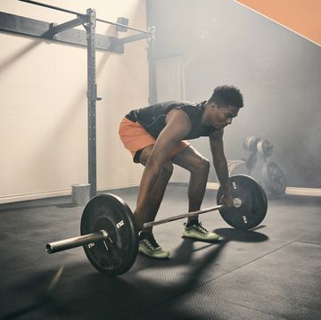 Man in gym weightlifting using barbell