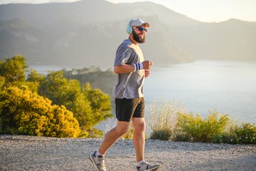 man in sportswear runs along the sea with a view of the mountains