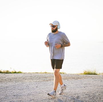 man in sportswear runs along the sea with a view of the mountains
