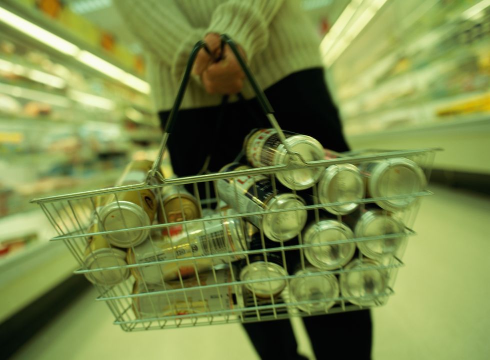 man in supermarket with basket full of beer