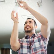 Man installs light fixture in new home
