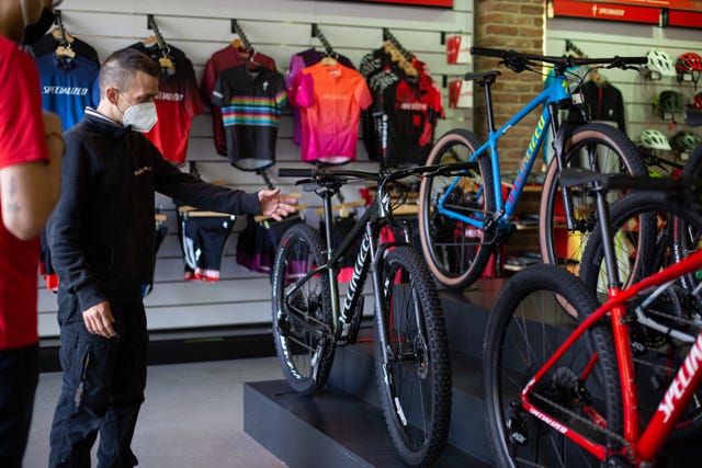 un vendedor de bicicletas muestra varios modelos a un cliente