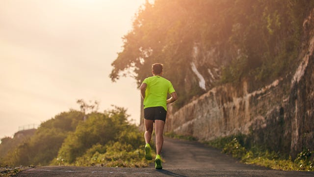 man jogging on a downhill  uphill in suburb mountain road