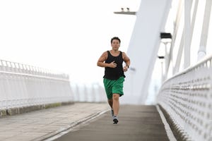 un hombre con sobrepeso corre para perder peso sobre un puente