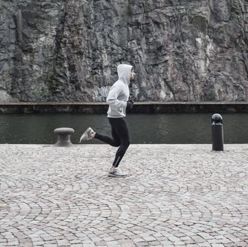 Man jogging on street against rock