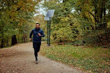 man jogging through a scenic forest trail in autumn