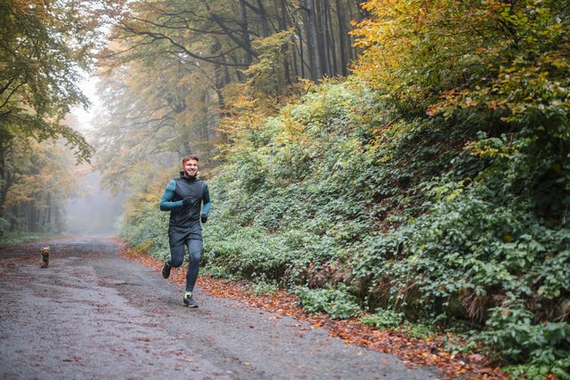 man jogging with his dog in autumn