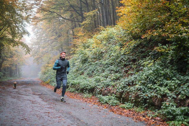 man jogging with his dog in autumn