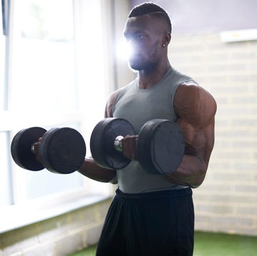 man lifting dumbbells in gym