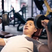 man lifting dumbbells in the gym