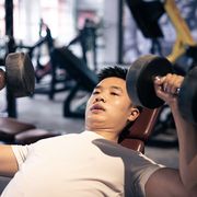 man lifting dumbbells in the gym