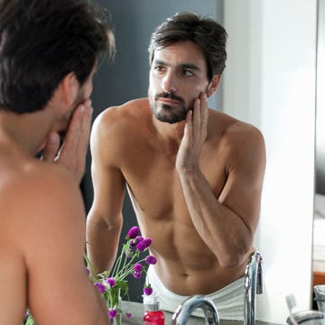 man looking at himself in bathroom mirror