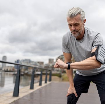 man looking at his smart watch to track his time while running outdoors
