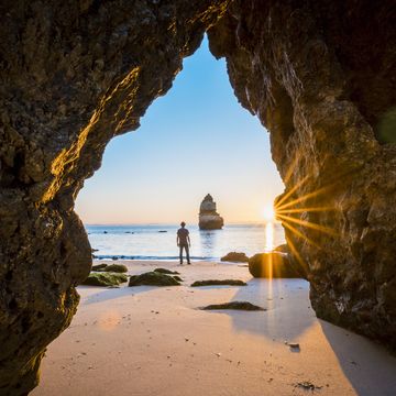een man kijkt uit over een strand in portugal