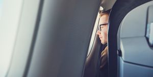 Man Looking Through Airplane Window