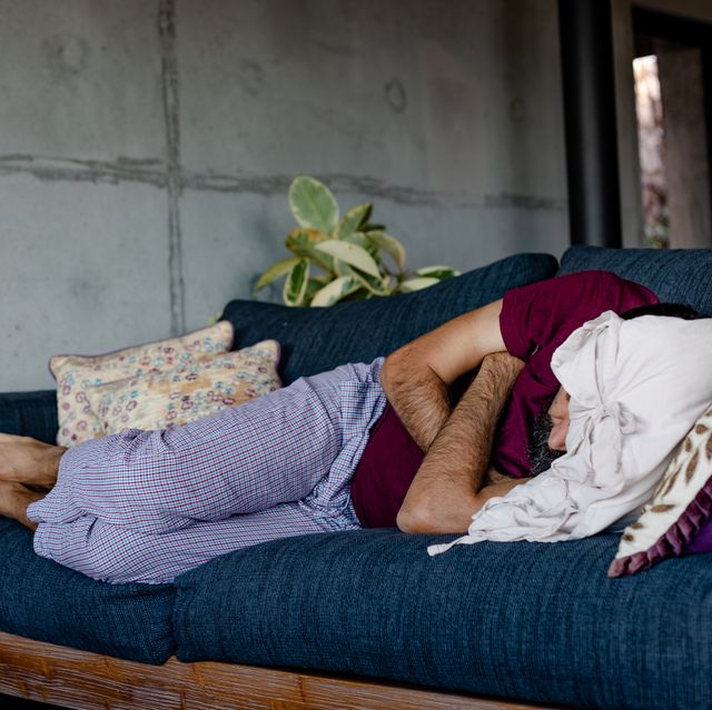 a man lying down on a sofa, sleeping