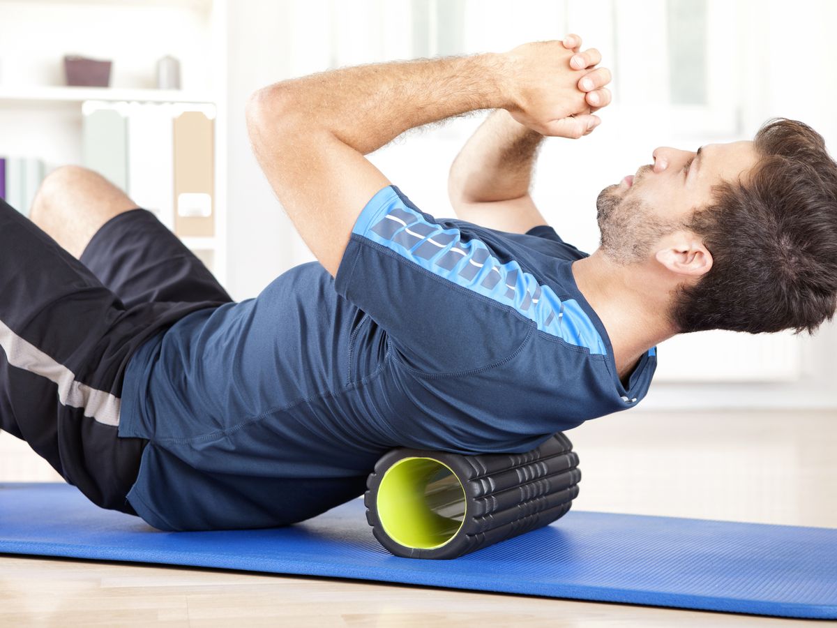 https://hips.hearstapps.com/hmg-prod/images/man-lying-on-a-foam-roller-while-doing-an-exercise-royalty-free-image-509421384-1545148853.jpg?crop=0.88866xw:1xh;center,top&resize=1200:*