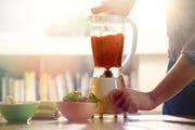man making a smoothie at home
