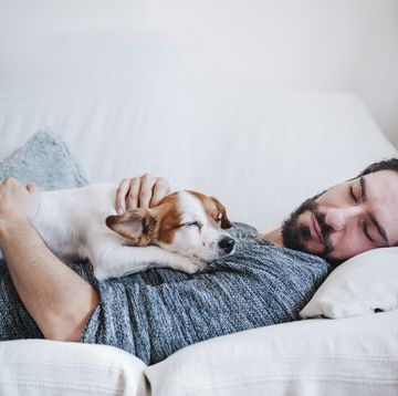 man napping with dog while lying on sofa at home, take a week off from exercise