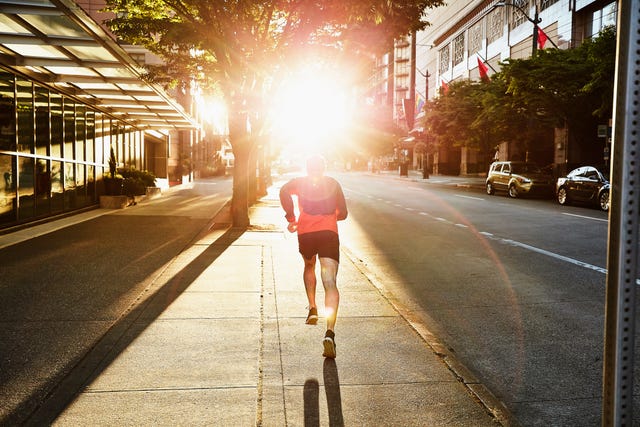 man on early morning run on empty city street