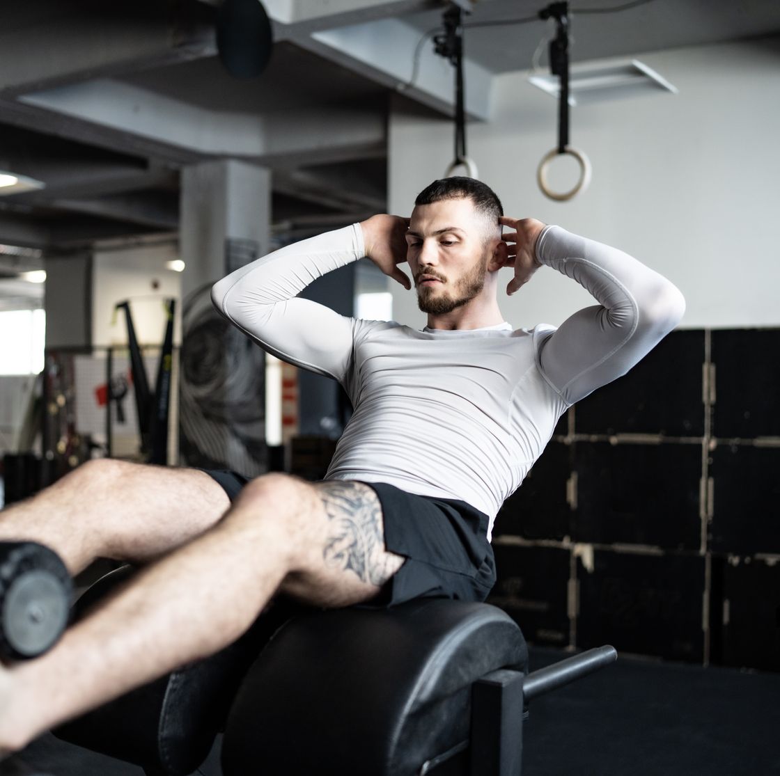 man performing abdominal exercise on gym equipment during workout