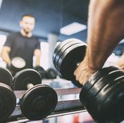 man picking up barbell in gym