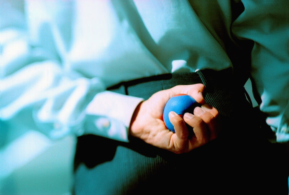 man playing boules, holding ball behind back, rear view
