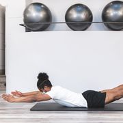 man practicing pilates on mat by wall at yoga studio during covid19