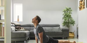 man practising yoga at home