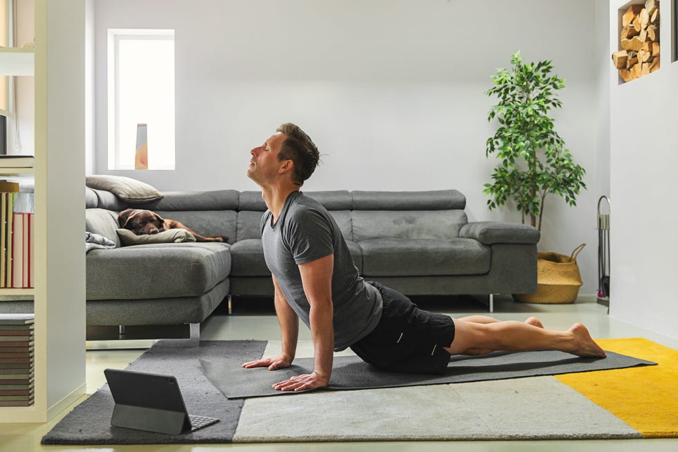 man practising yoga at home