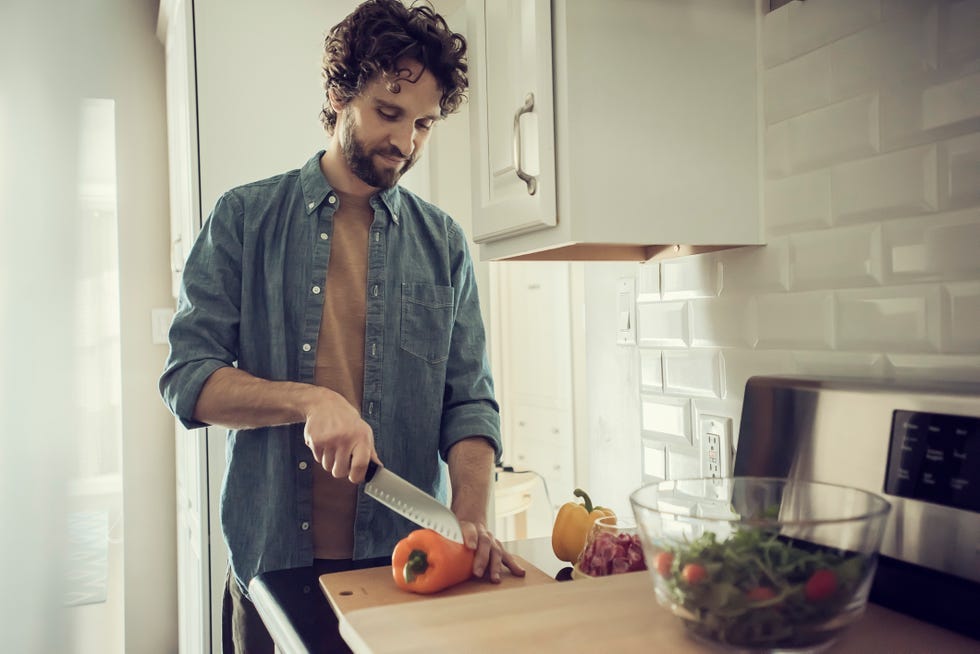 person chopping vegetables in a modern kitchen