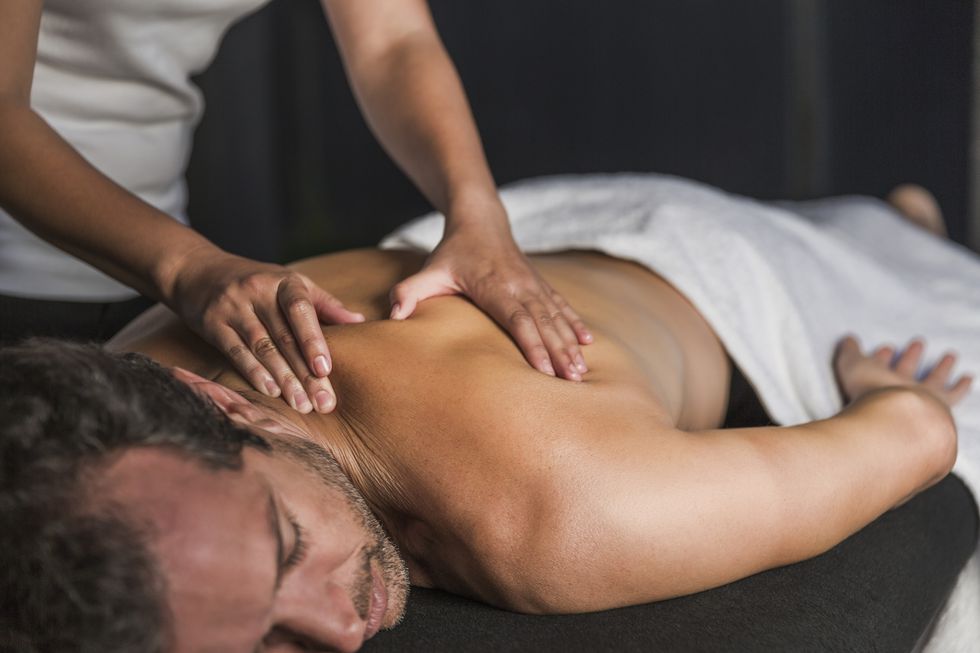 man receives back massage in spa