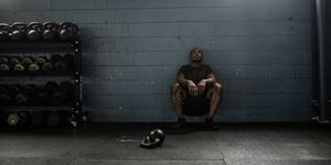 man resting against wall at cross training gym