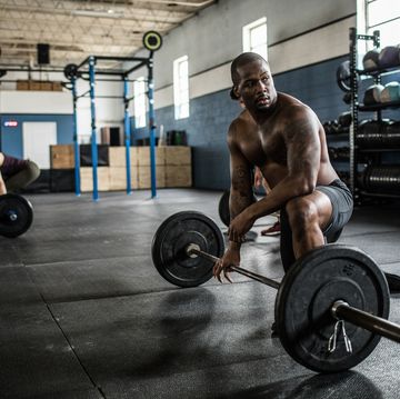 man resting in between sets at cross training gym