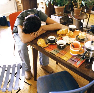 man resting on table in front of breakfast