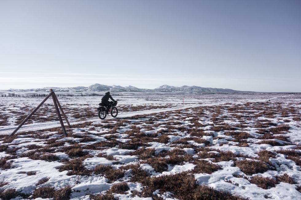 Man rides across remote frozen landscape