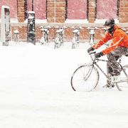 man riding bicycle on snow covered road, cycling in snow, biking on ice