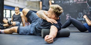 Man rolling on foam roller at health club