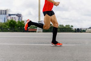 man runner in black compression socks run city marathon