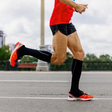 man runner in black compression socks run city marathon