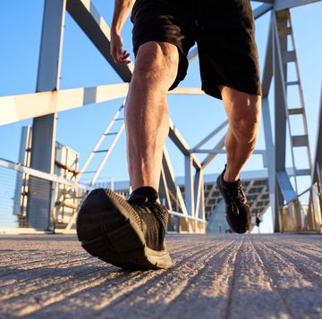 man running on a bridge in the city.