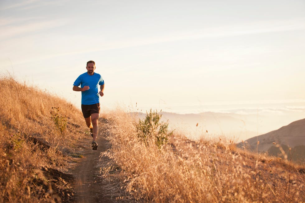 Man running on grassy hillside