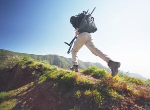 man running on grassy road in mountains