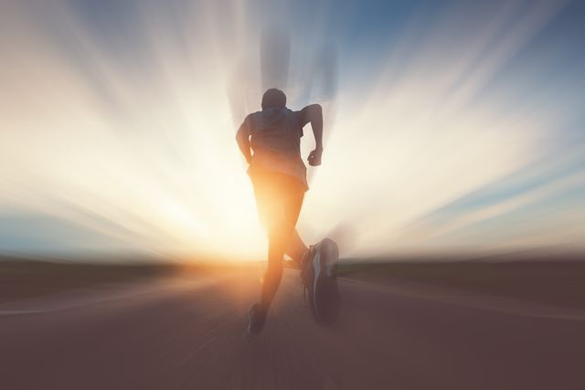 man running on road against sky during sunset